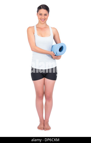 Cheerful slender model holding her rolled up mat Stock Photo