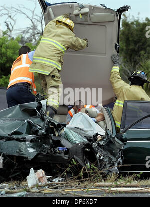 Oct 26, 2006; Ft. Pierce, FL, USA; St. Lucie County Fire District rescue workers peel back a car's roof to get to a seriosly injured man Thursday morning. This car was southbound on U. S. 1 north of Fort Pierce late Thursday morning when it was forced off the road by an alleged drunk driver. The car smashed head-on into a tanker truck watering plants in the median. The driver and a Stock Photo