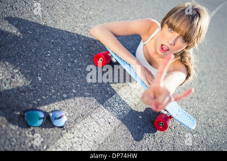 Cool skater girl doing rock and roll hand gesture Stock Photo