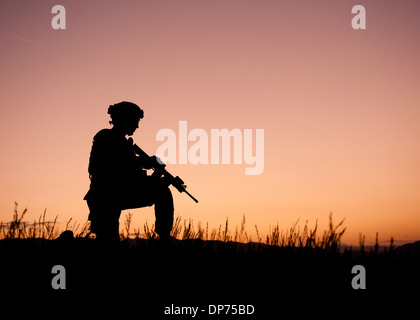 A US Army soldier is silhouetted against the setting sun during a mission September 6, 2011 in the Orgun-E district, Paktika province, Afghanistan. Stock Photo
