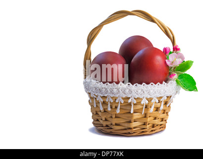 Three Easter eggs, painted in red, are beautifully decorated with wicker basket. Presented on a white background. Stock Photo