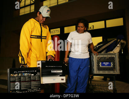 Nov 17, 2006; West Palm Beach, FL, USA; Andres Erazo, 19, and his mother Doris Lozano of Miami, walk out of the Walmart at Military Trail and Belvedere after purchasing two Playstation 3's.  Erazo and his mother were the first to purchase the system at this Walmart.  He planned to keep one and sell the other.  'Feels great man, 40 something hours later, I haven't slept, called off  Stock Photo