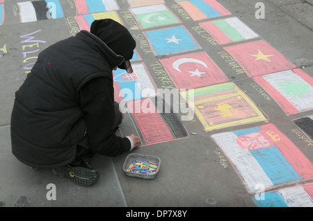 Street artist drawing the flags of the world on the pavement in chalk in Trafalgar Square, London, UK. Stock Photo