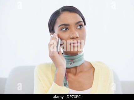 Cheerful elegant woman sitting on sofa having a phone call Stock Photo