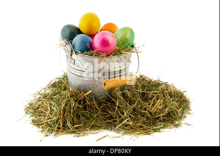 Sinc bucket with straw and colorful painted easter eggs Stock Photo