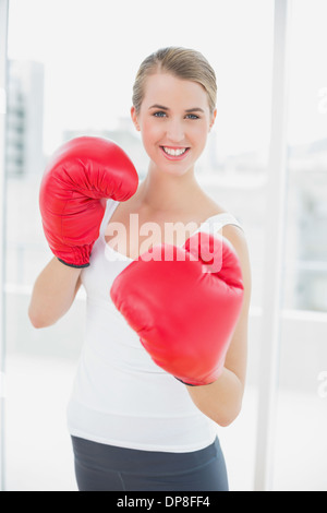 Smiling fit woman with red gloves boxing Stock Photo