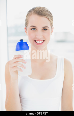 Happy sporty woman holding flask Stock Photo