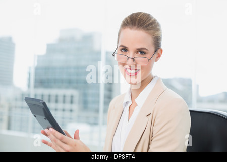 Cheerful businesswoman with glasses using calculator Stock Photo