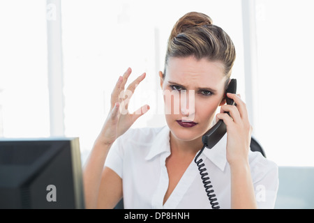 Angry businesswoman talking on the phone Stock Photo