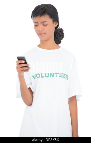 Frowning black haired volunteer texting with her mobile phone Stock Photo