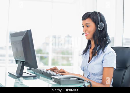 Happy operator typing on her computer Stock Photo