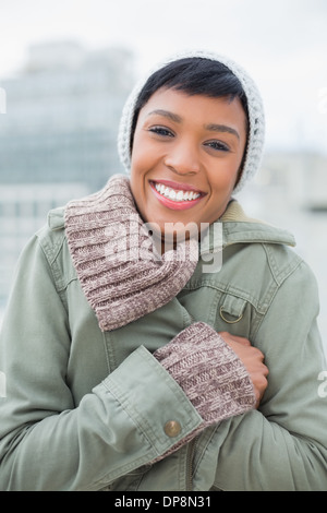 Delighted young model in winter clothes closing her jacket