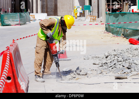 A steel fixer carefully tying reinforced steel bars in position in preparation for the construction of a concrete slab Stock Photo