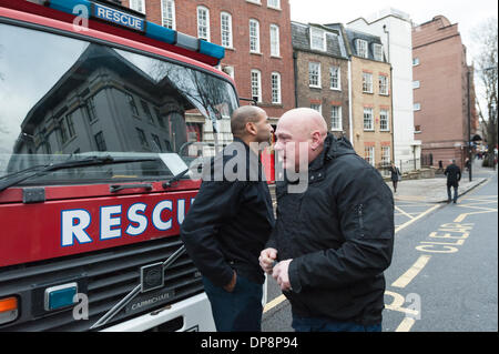 London, UK. 9th January, 2014. Two firefighters console one another as they leave Clerkenwell Fire Station for the last time. The closure is part of a controversial cost-cutting policy instigated by the Mayor of London, Boris Johnson. Credit:  Lee Thomas/Alamy Live News Stock Photo