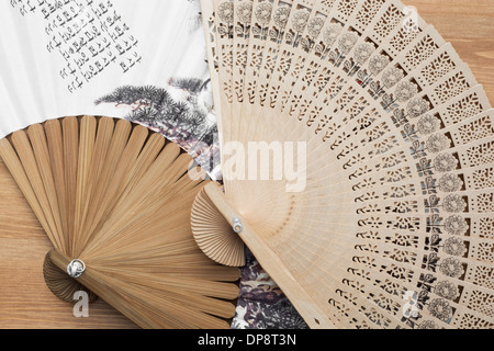 Traditional fans with far eastern motive on a wooden background. Stock Photo
