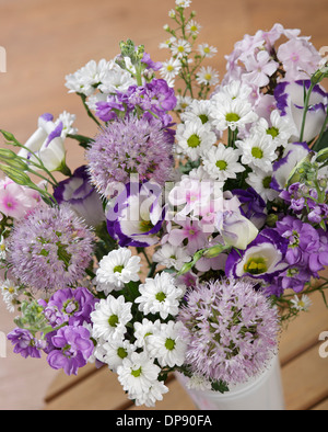 Bouquet of lilac Alliums, Santini Chrysanthemums, pink Phlox, purple Stocks, blue Lisianthus and white Aster in a vase in a home setting Stock Photo