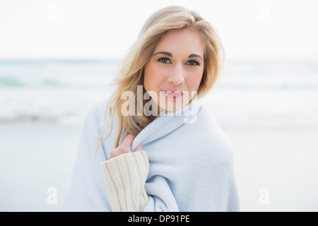 Content blonde woman covering herself in a blanket Stock Photo