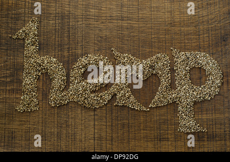 The word Hemp written artistically in hemp seeds on a wooden chopping board, with a heart shape integrated into the word. Stock Photo