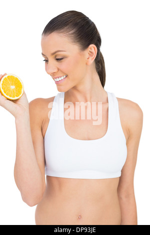 Smiling woman holding orange slice Stock Photo