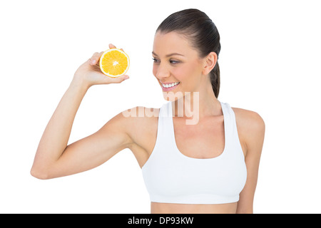 Smiling woman in sportswear holding orange slice Stock Photo