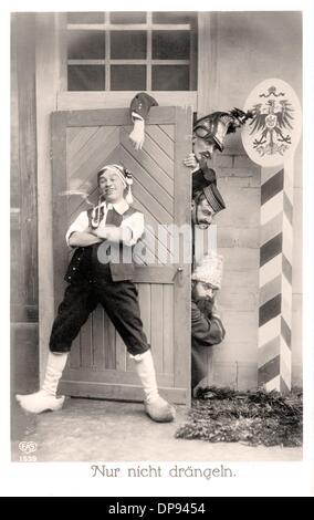 A postcard shows a retouched photograph depicting a giant German who leans against a wooden door through which three small soldiers - symbolizing the French, Russian, and British Army - try to thrust their way. 'Don't push!' is written under the propagandistic image. Photo: Sammlung Sauer Stock Photo