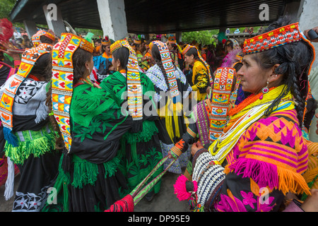 Kalash woman watching women and girls dancing at the Anish Brun Village Charso (dancing ground), Kalash Joshi (Spring Festival), Bumburet Valley, Chitral, Khyber-Pakhtunkhwa, Pakistan Stock Photo