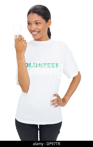 Smiling model wearing volunteer tshirt holding light bulb Stock Photo