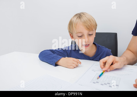 Cropped image of father assisting boy in studies Stock Photo