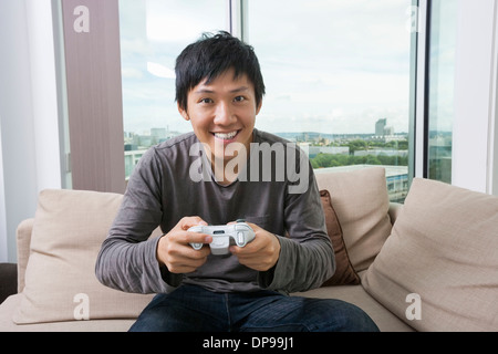 Excited mid adult man playing video game on sofa Stock Photo