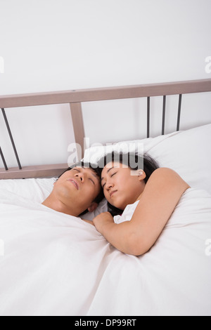Asian couple sleeping in bed Stock Photo