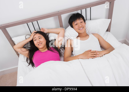 Satisfied young couple in bed Stock Photo