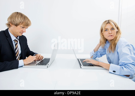 Portrait of businesswoman with coworker using laptop in office Stock Photo
