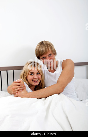 Portrait of happy couple embracing in bed Stock Photo