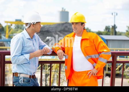 Architects standing against railing at construction site Stock Photo