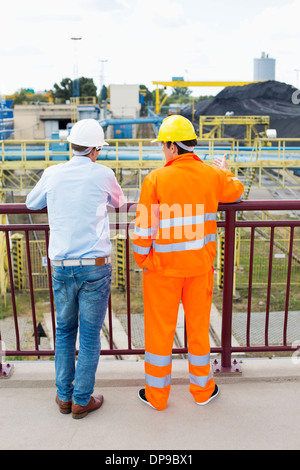 Back view of architects standing against railing at construction site Stock Photo