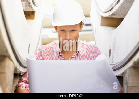 Architect reviewing blueprint at construction site Stock Photo