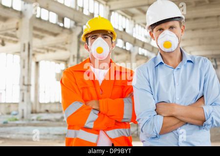 Portrait of confident male construction workers in protective workwear at site Stock Photo