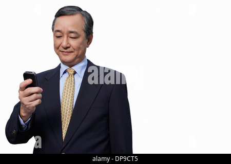 Businessman text messaging on cell phone over white background Stock Photo