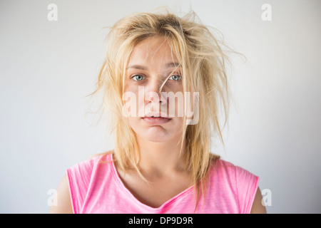 Portrait of frustrated woman suffering from cold against gray background Stock Photo