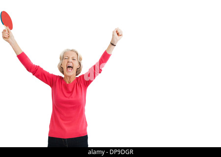 Happy senior female table tennis player with arms raised celebrating victory Stock Photo