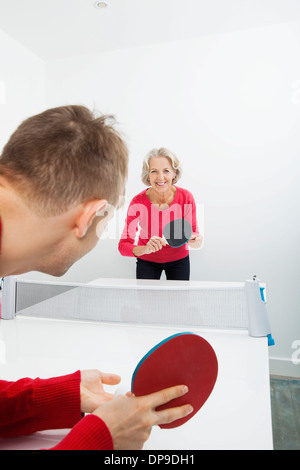 Portrait of senior woman playing table tennis in court Stock Photo