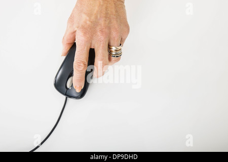 Senior businesswoman's hand using computer mouse Stock Photo