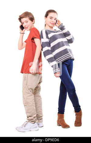 two smiling teenager, back on back with their mobile phones, isolated on white. Stock Photo