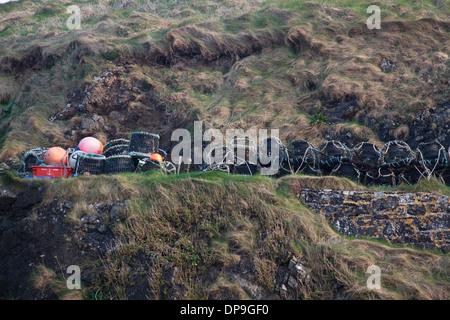 Crob and lobster pots lined up on the rocks at Mullion Cove, Lizard Peninsula, Cornwall Stock Photo