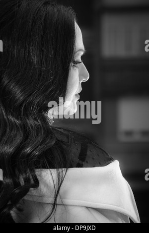 Portrait of beautiful woman looking away in darkness with light on her face. Black and white portrait, low key Stock Photo