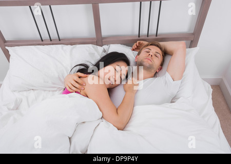 Multiethnic couple sleeping in bed Stock Photo