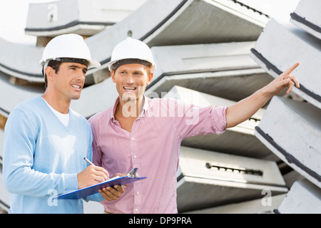 Smiling architects inspecting stock at site Stock Photo