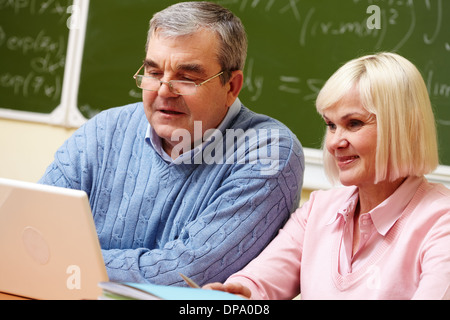 Elderly people using modern technologies for studying Stock Photo