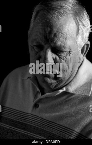 Sad looking lonesome elderly man eating birthday cake alone at home in ...