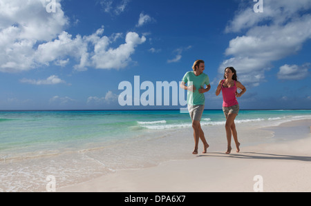 Couple running on beach Stock Photo